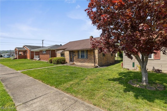 view of front of home with a front lawn and stone siding