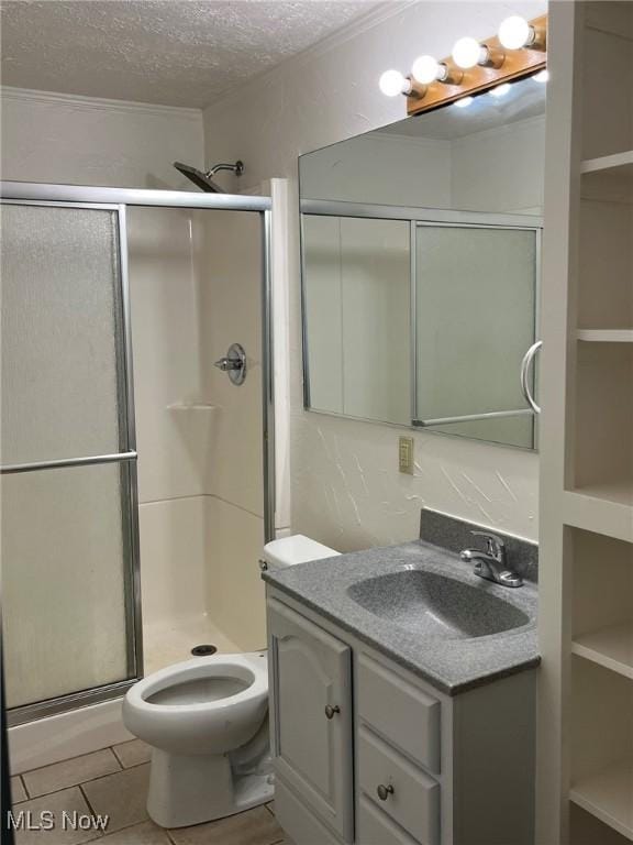 bathroom featuring a shower stall, a textured ceiling, vanity, toilet, and tile patterned floors