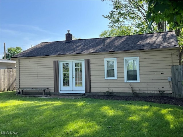 rear view of house featuring a chimney, roof with shingles, and french doors