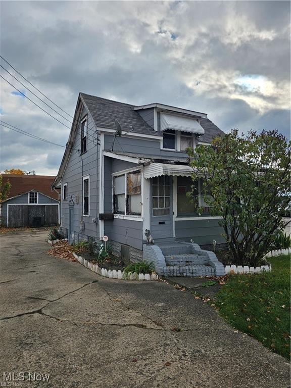 view of front of home with driveway and a shingled roof