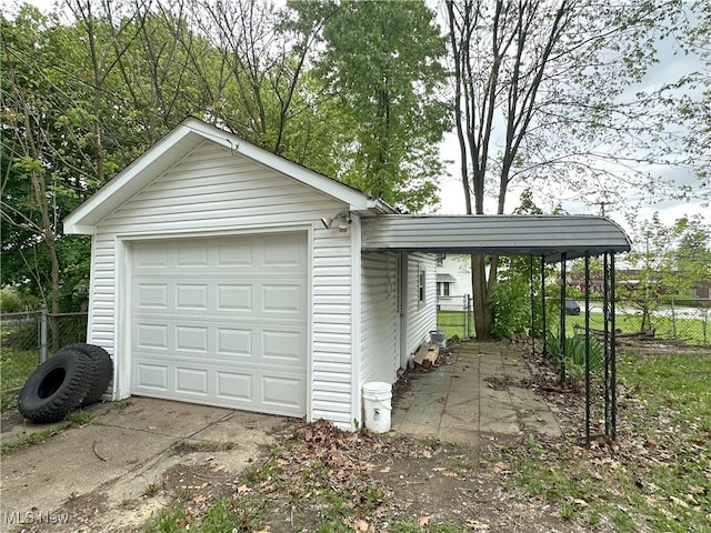 detached garage with fence and concrete driveway