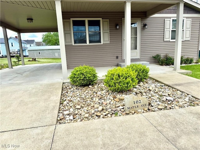 102 Maple, Bethesda, OH 43719 - property entrance with driveway, a porch, and an attached carport