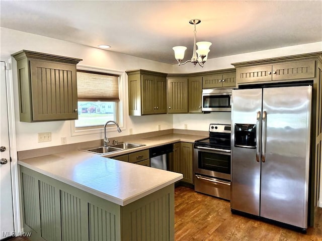 102 Maple, Bethesda, OH 43719 - kitchen with appliances with stainless steel finishes, a sink, a peninsula, dark wood-style floors, and a chandelier
