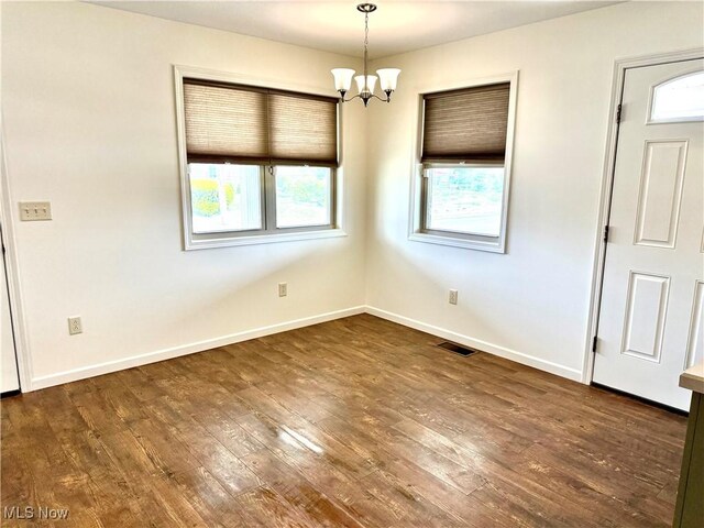 102 Maple, Bethesda, OH 43719 - spare room with healthy amount of natural light, a chandelier, hardwood / wood-style floors, and baseboards