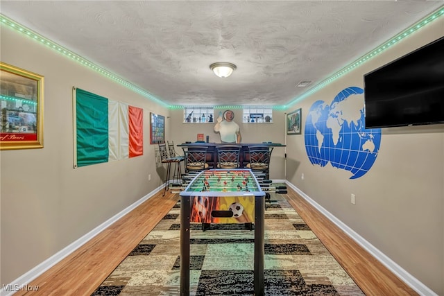 3475 Clague Rd, North Olmsted, OH 44070 - rec room with a bar, wood finished floors, baseboards, crown molding, and a textured ceiling