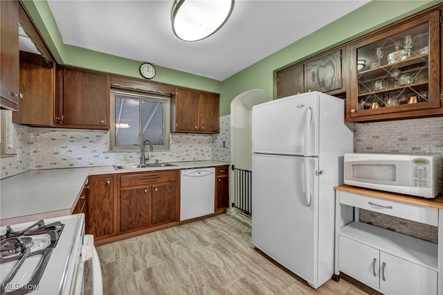 3475 Clague Rd, North Olmsted, OH 44070 - kitchen with white appliances, a sink, tasteful backsplash, light countertops, and glass insert cabinets