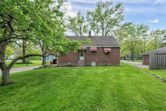 3475 Clague Rd, North Olmsted, OH 44070 - rear view of property with brick siding, a yard, cooling unit, and a chimney