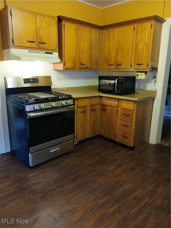 3609 Stoer Rd, Shaker Heights, OH 44122 - kitchen with stainless steel gas range, under cabinet range hood, black microwave, crown molding, and dark wood-type flooring