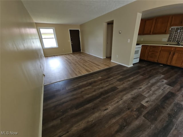 681 Longcoy Ave, Kent, OH 44240 - unfurnished living room featuring dark wood-style flooring, a sink, and baseboards