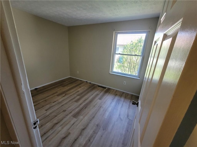 681 Longcoy Ave, Kent, OH 44240 - spare room with wood finished floors, a textured ceiling, and baseboards