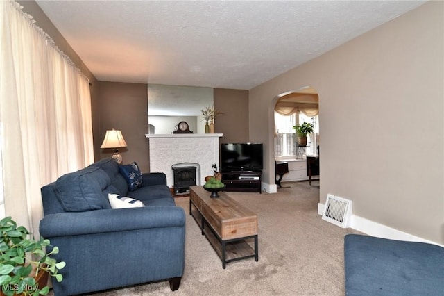 1255 Gorge Blvd, Akron, OH 44310 - carpeted living area with arched walkways, a fireplace, a textured ceiling, and baseboards