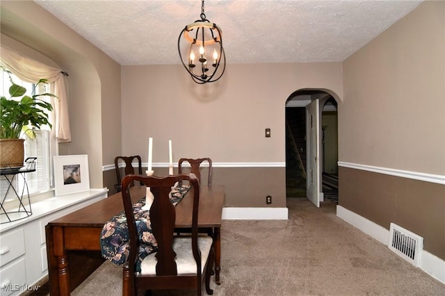 1255 Gorge Blvd, Akron, OH 44310 - dining space with arched walkways, carpet flooring, a textured ceiling, a chandelier, and baseboards