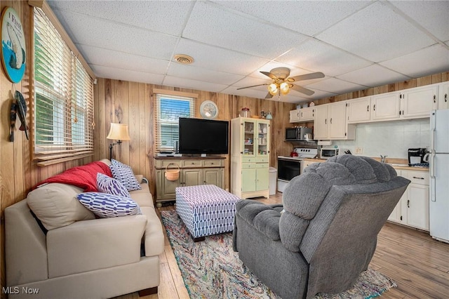 5755 Lake Rd W Unit 6, Ashtabula, OH 44004 - living area featuring a paneled ceiling, wood walls, plenty of natural light, a ceiling fan, and wood finished floors