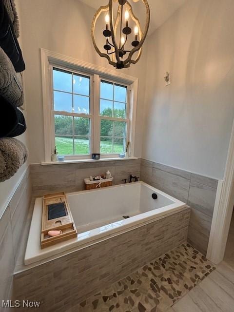 4718 Brushwood Rd, Wakeman, OH 44889 - full bathroom featuring a chandelier, a bath, tile patterned flooring, and a wainscoted wall