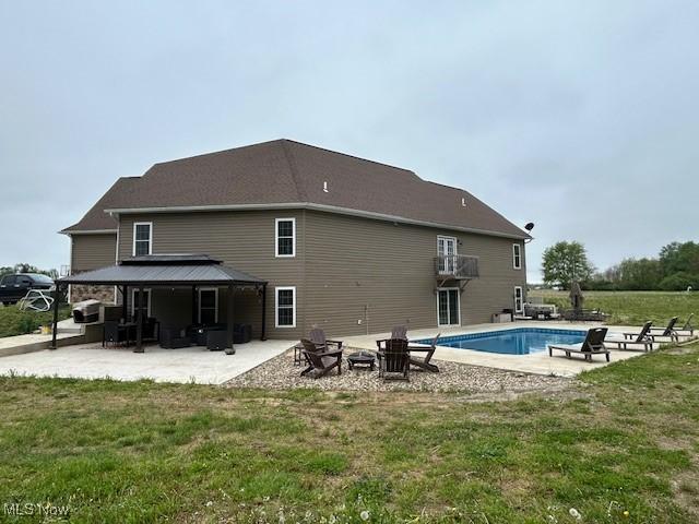 4718 Brushwood Rd, Wakeman, OH 44889 - back of house featuring a gazebo, a patio area, a fire pit, a yard, and an outdoor pool