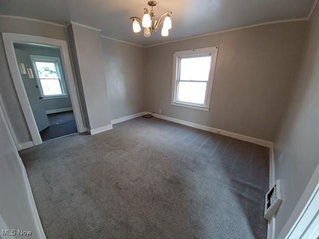 438 Elberen St, Youngstown, OH 44509 - empty room with healthy amount of natural light, dark carpet, a chandelier, baseboards, and crown molding