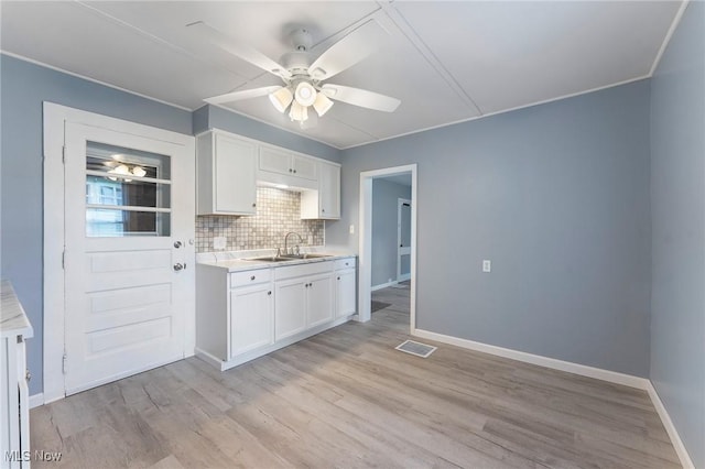 215 Holford Ave, Niles, OH 44446 - kitchen with white cabinets, a ceiling fan, light countertops, tasteful backsplash, and crown molding