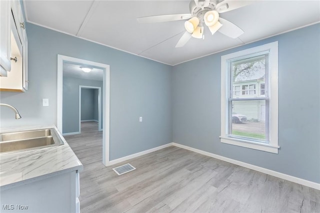215 Holford Ave, Niles, OH 44446 - kitchen with a sink, light wood-style flooring, white cabinetry, baseboards, and crown molding