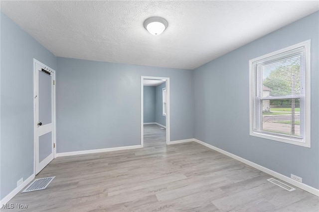 215 Holford Ave, Niles, OH 44446 - spare room featuring light wood finished floors, baseboards, and a textured ceiling