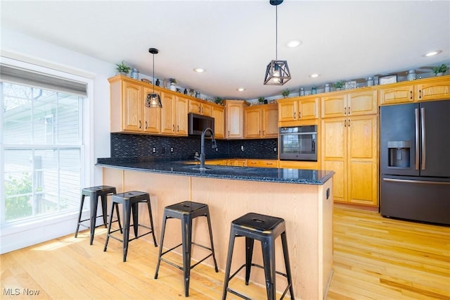 99 Township Road 262, Bloomingdale, OH 43910 - kitchen featuring black appliances, light wood-type flooring, a peninsula, tasteful backsplash, and a kitchen bar
