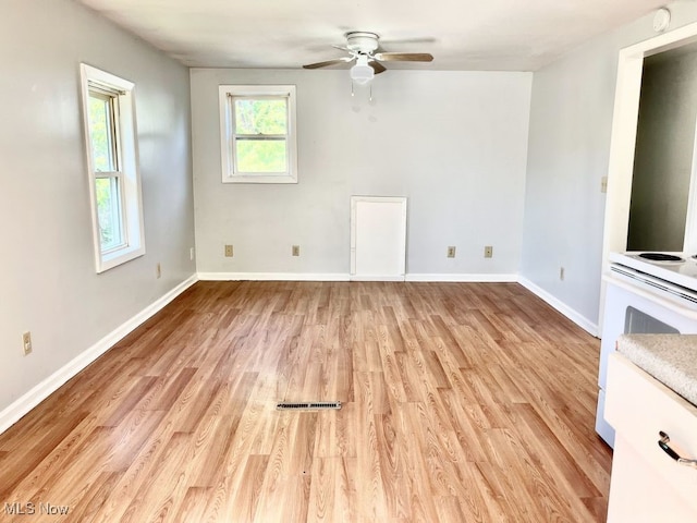 1104 4th St SW, Massillon, OH 44647 - unfurnished living room with a ceiling fan, light wood-style flooring, and baseboards