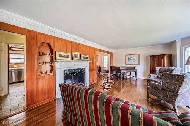 living area featuring crown molding, a high end fireplace, and wood finished floors