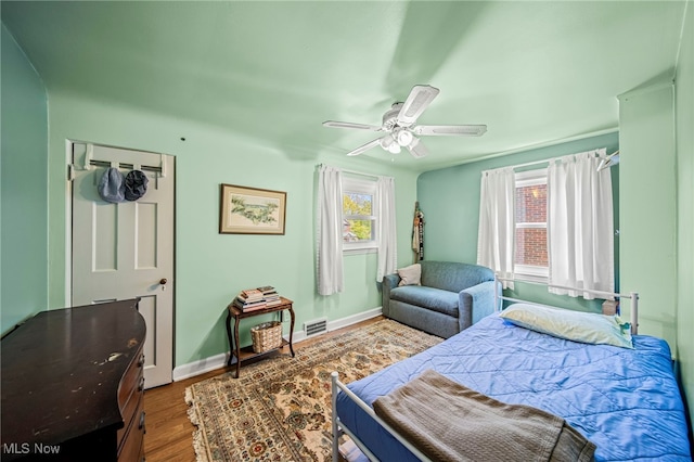 bedroom with wood finished floors, ceiling fan, and baseboards