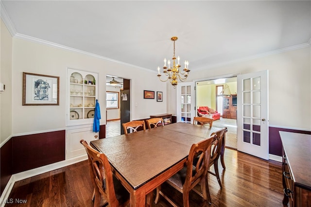 dining room with french doors, crown molding, dark wood-style floors, a chandelier, and baseboards