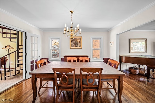 dining room with wood finished floors, a chandelier, and ornamental molding