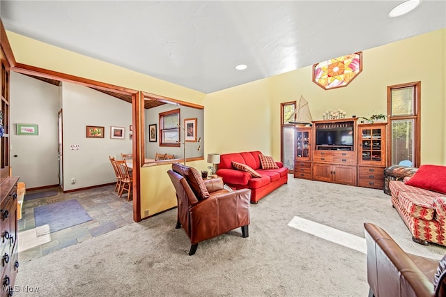 living area with stone finish floors, baseboards, and recessed lighting