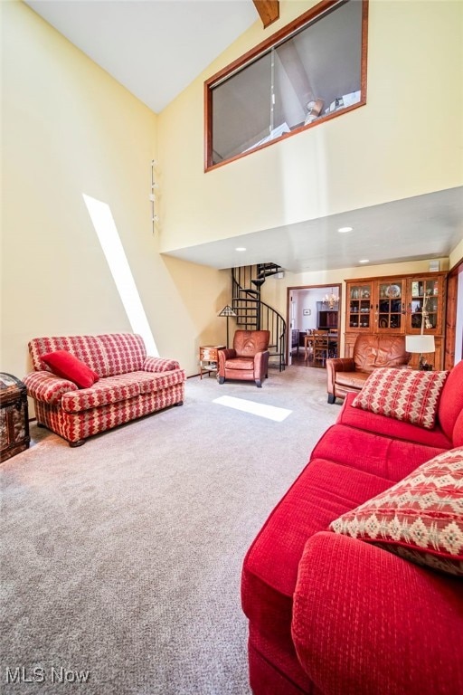 living area with carpet and high vaulted ceiling