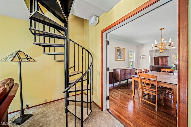 staircase featuring a chandelier, baseboards, carpet, and ornamental molding