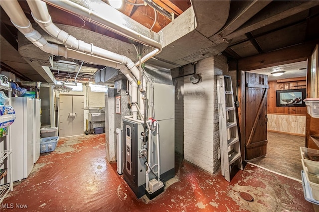 below grade area featuring heating unit, a sink, and wood walls