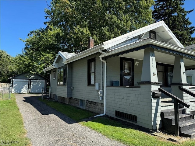 view of front of property with a chimney, an outbuilding, covered porch, and a garage
