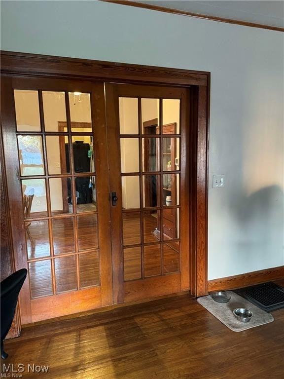 entryway featuring french doors, dark wood-type flooring, and crown molding