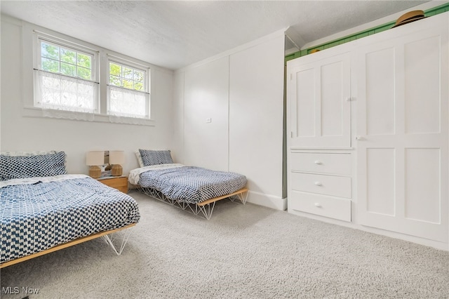 carpeted bedroom featuring a textured ceiling