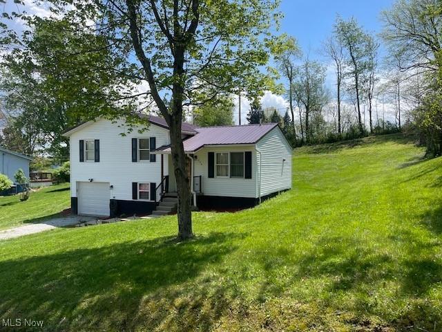 206 Anderson Ave, Bethesda, OH 43719 - back of property with an attached garage, driveway, a lawn, and metal roof