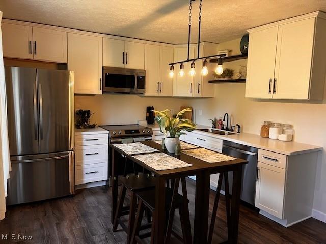 206 Anderson Ave, Bethesda, OH 43719 - kitchen featuring appliances with stainless steel finishes, a sink, a textured ceiling, light countertops, and dark wood finished floors