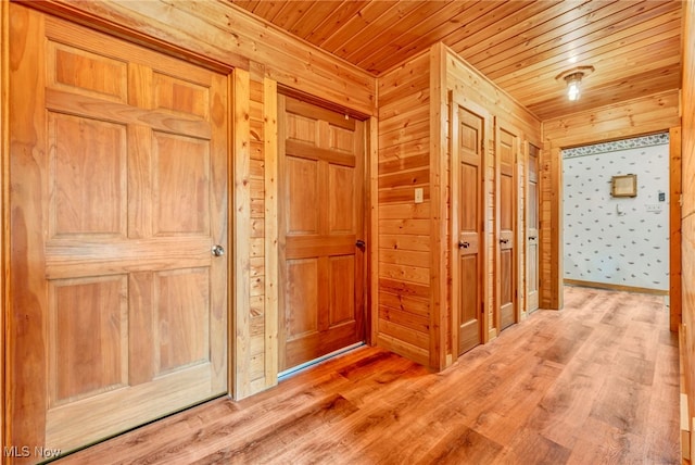 hallway featuring wooden ceiling, wood finished floors, and wood walls