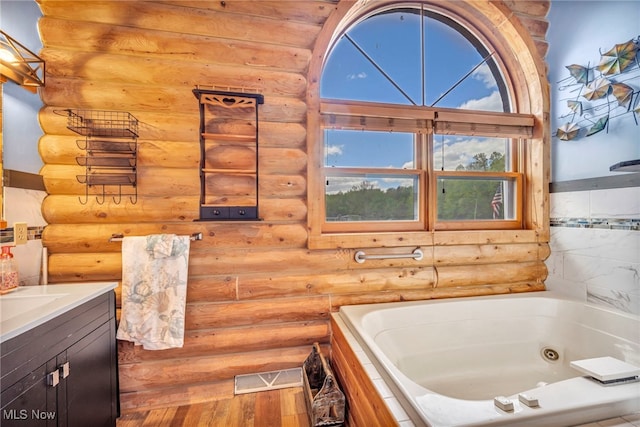 15180 Stoltz Rd, Diamond, OH 44412 - bathroom featuring log walls, a whirlpool tub, vanity, and wood finished floors