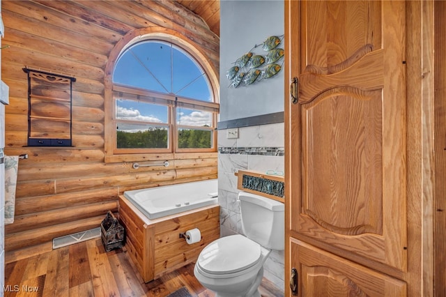 bathroom featuring toilet, hardwood / wood-style floors, and log walls