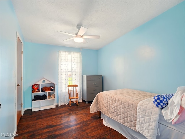 bedroom featuring wood finished floors, a textured ceiling, and a ceiling fan