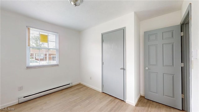 32 Ash Cir, Davisville, WV 26142 - unfurnished bedroom with baseboard heating, light wood-type flooring, and baseboards