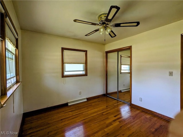 316 S Inglewood Ave, Austintown, OH 44515 - unfurnished bedroom with dark wood-type flooring, baseboards, a closet, ceiling fan, and a baseboard heating unit