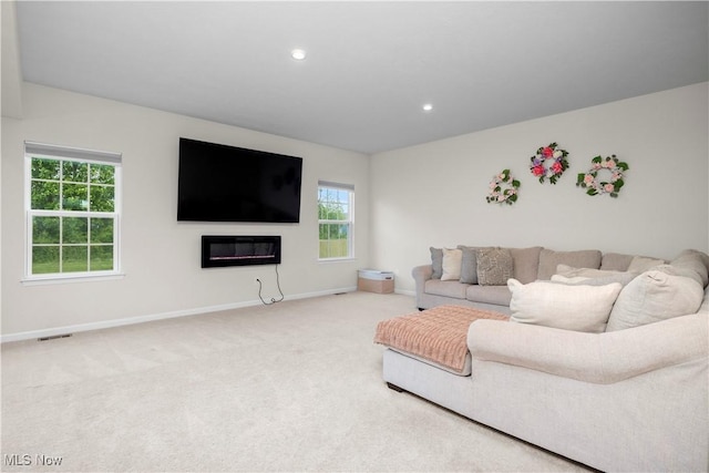 9087 Nash Ln, North Ridgeville, OH 44039 - carpeted living room featuring healthy amount of natural light, baseboards, recessed lighting, and a glass covered fireplace