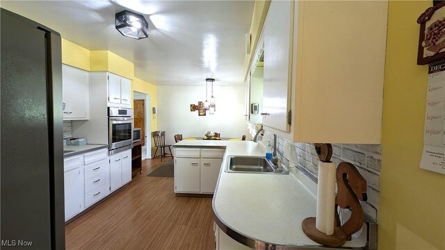 6291 Veterans Blvd, Chester, WV 26034 - kitchen featuring stainless steel appliances, a sink, wood finished floors, white cabinets, and light countertops