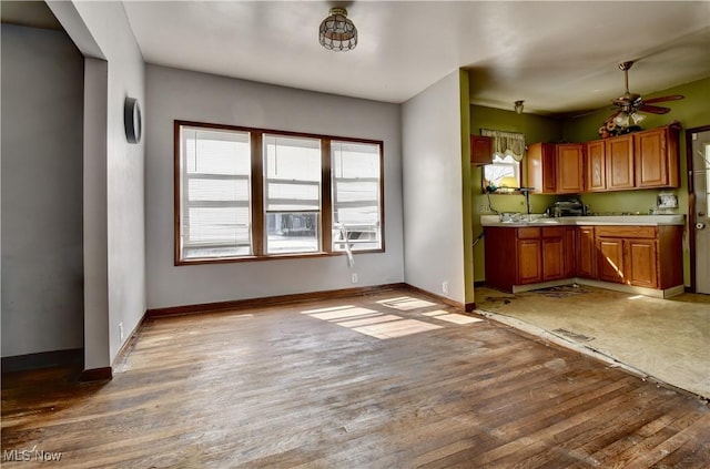 17 Spring St, Dennison, OH 44621 - kitchen featuring light countertops, light wood-type flooring, brown cabinetry, baseboards, and a ceiling fan