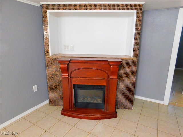 detailed view of a glass covered fireplace, baseboards, and crown molding