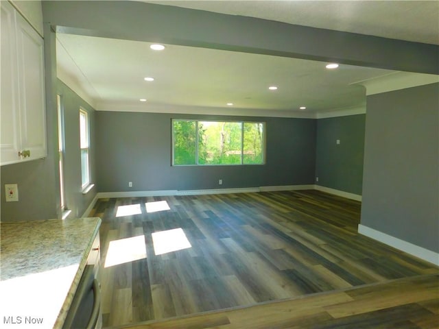 unfurnished room featuring recessed lighting, healthy amount of natural light, baseboards, dark wood finished floors, and crown molding