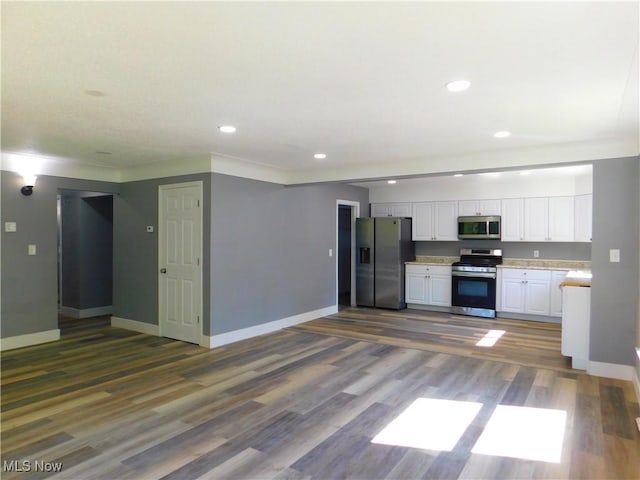 kitchen featuring appliances with stainless steel finishes, white cabinets, light countertops, baseboards, and recessed lighting